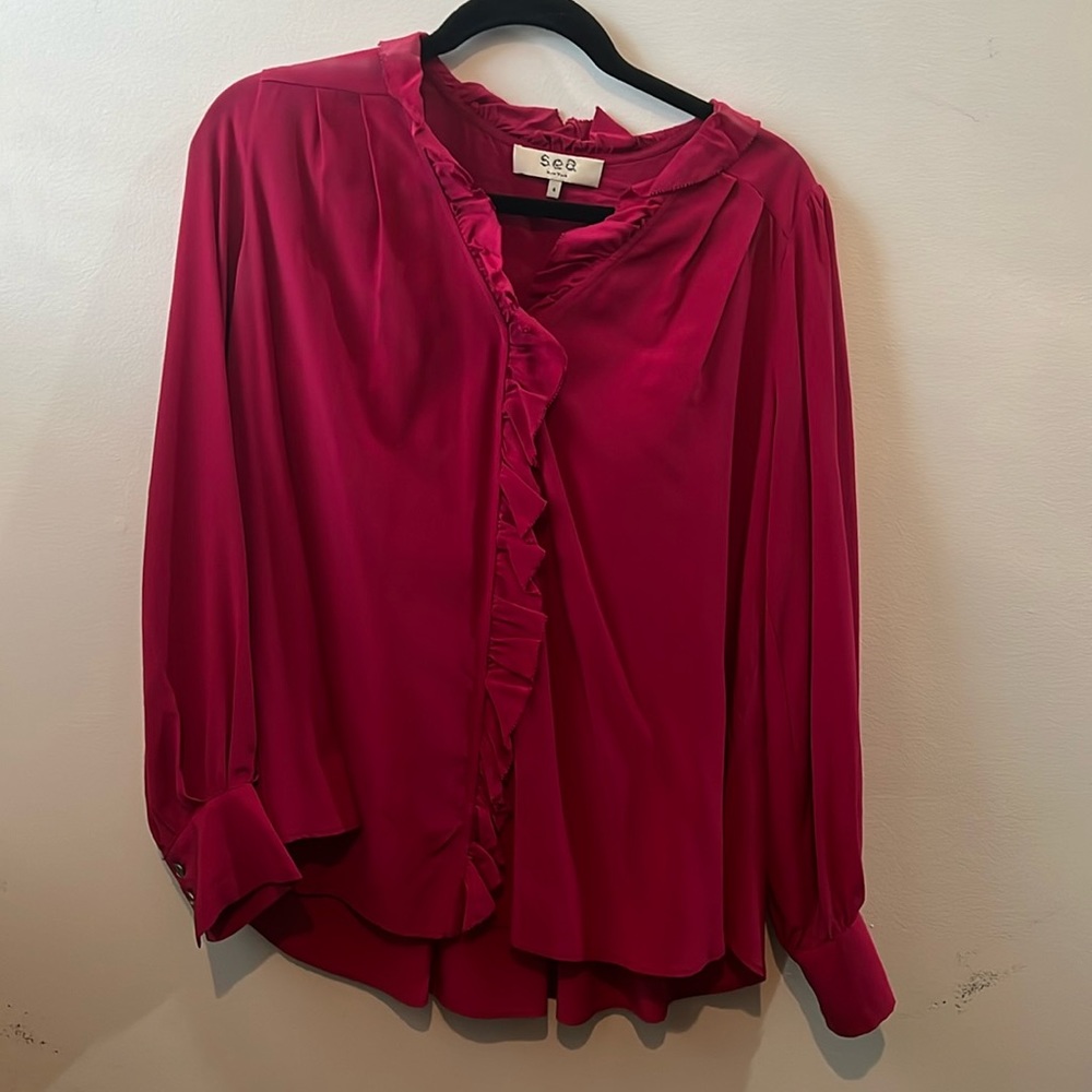 Dark pink top. Slightly lower in the back.